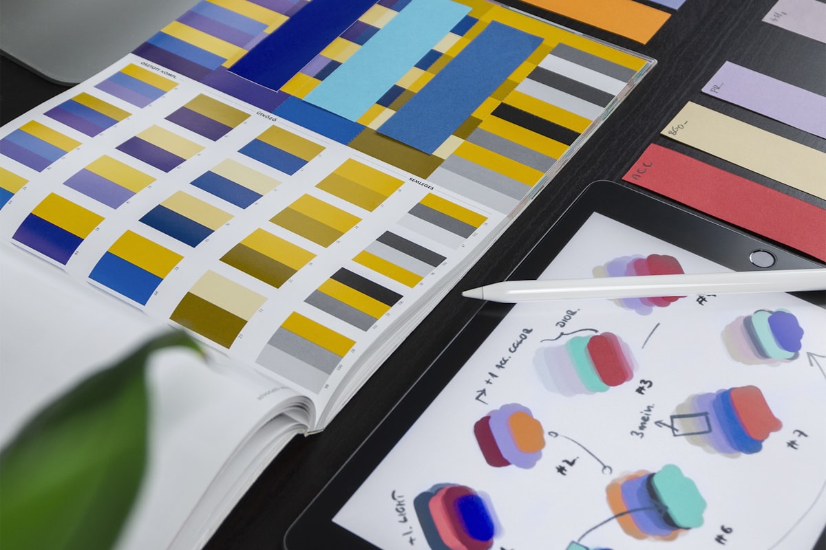 Design desk with color swatches and a tablet showing interface color studies